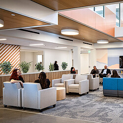 A group of people sitting in a room with white couches.
